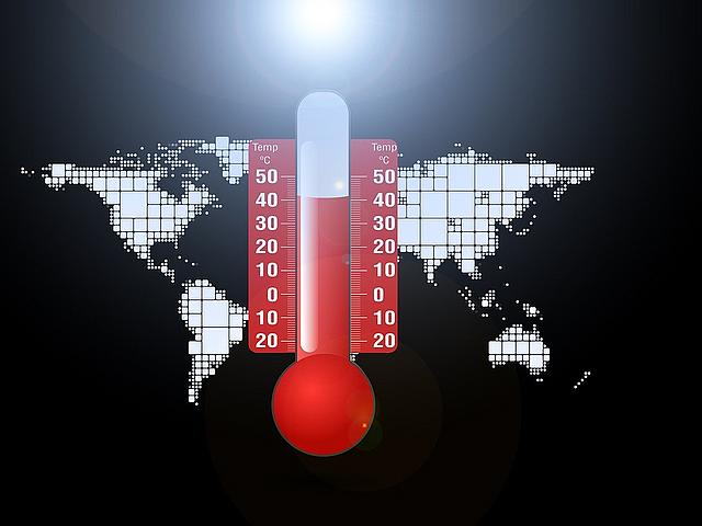 Thermometer mit hohner Temperaturanzeige vor Weltkarte