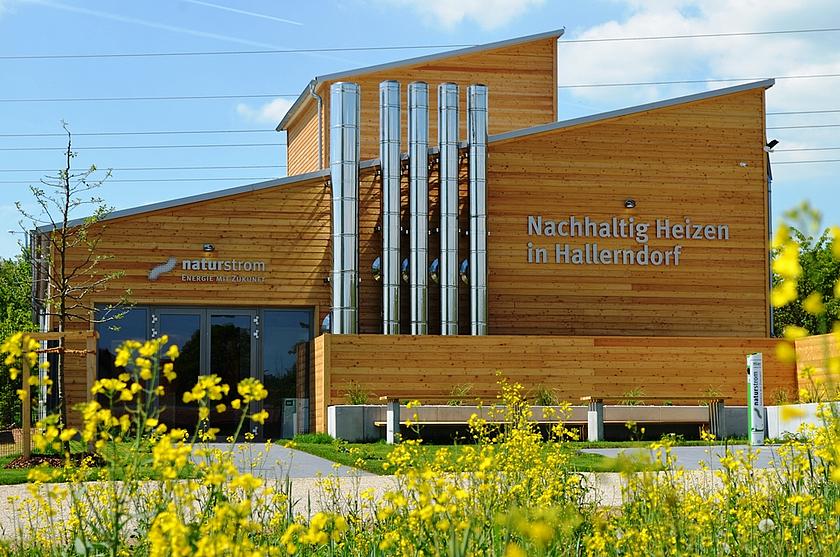 Die Energiezentrale in der oberfränkischen Gemeinde Hallerndorf, ein Holzbau mit großer Fensterfront, lässt Einblicke in die erfolgreiche Wärmewende Hallerndorfs zu. 