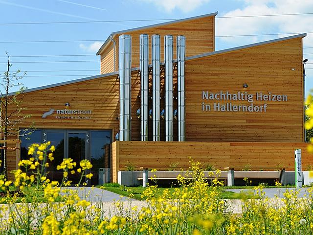 Die Energiezentrale in der oberfränkischen Gemeinde Hallerndorf, ein Holzbau mit großer Fensterfront, lässt Einblicke in die erfolgreiche Wärmewende Hallerndorfs zu. 