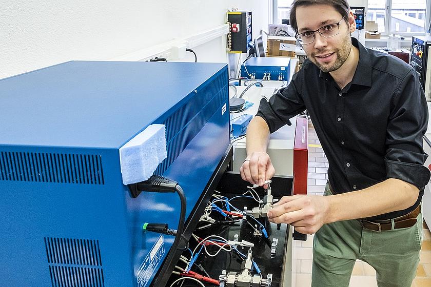 Empa-Forscher Ruben-Simon Kühnel schließt eine Test-Batteriezelle mit der konzentrierten Salzlösung an ein Ladegerät an. (Foto: © Empa)