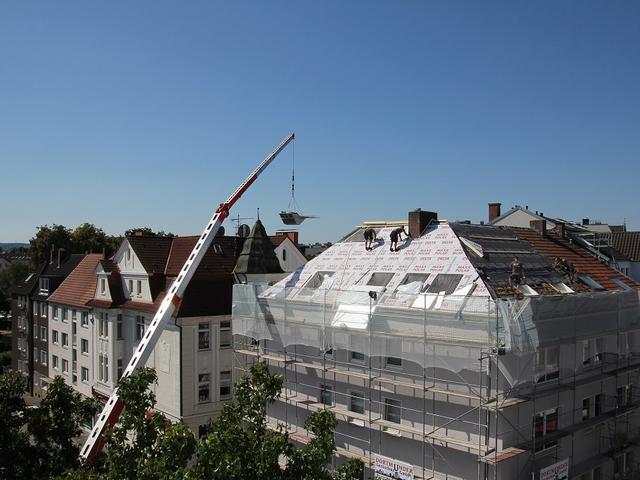 Gebäudebaustelle mit Dachdeckerarbeiten
