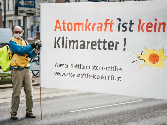 Demonstrant hält Plakat mit Botschaft „Atomkraft ist kein Klimaretter“ bei einer Klimademo