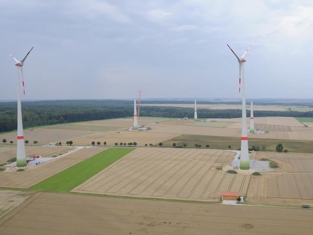 Fertige und im Bau befindliche Windkrafträder auf Feldern