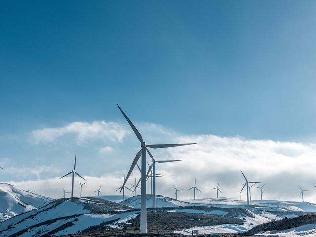Windkraftanlagen auf halbwegs schneebedeckten Bergen