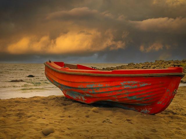 Rotes Boot an Land, bedrohliche Wolken