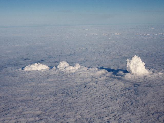 Dampfwolken der Braunkohlekraftwerke Frimmersdorf (links), Neurath (Mitte) und Niederaußem (rechts) aus Wasserdampf und CO2 durchstoßen die Wolkenschicht. (Foto: © <a href="https://de.wikipedia.org/wiki/Datei:FrimmersdorfWolke7.JPG">Arne Hückelheim</a>, <a href="https://creativecommons.org/licenses/by-sa/4.0/" target="_blank">CC BY-SA 4.0</a>)