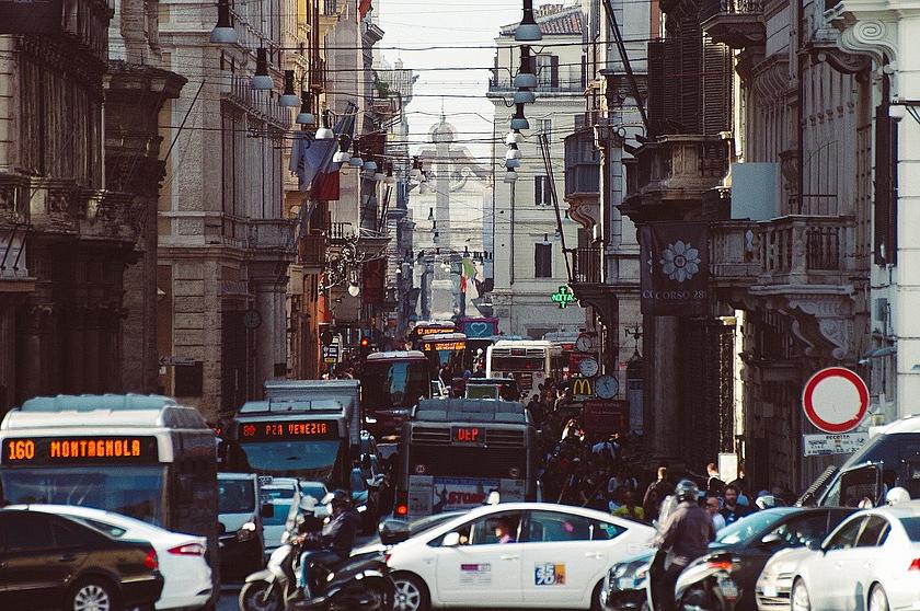 EIn Bild verstopfter Straßen in Rom, voller Busse und Autos in Häuserschluchten.