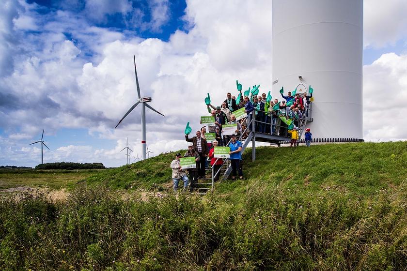 Menschengruppe vor Windkraftanlage