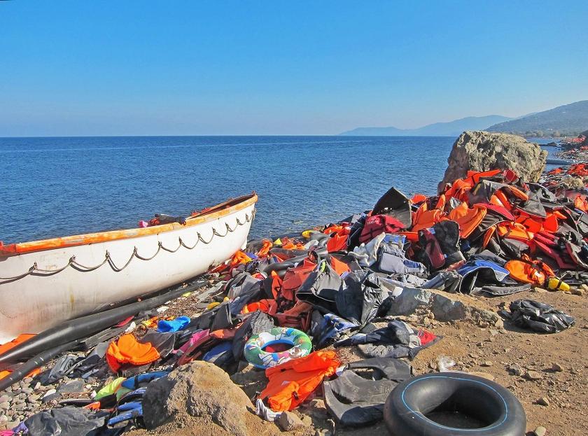 Verlassenes Flüchtlingsboot am Strand, Rettungswesten und Plastikmüll