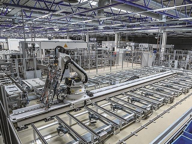 Fabrikhalle mit Maschinen zur Solarmodulproduktion.