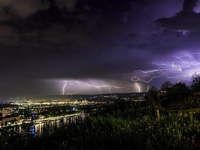Foto: Bild eines herannahenden Gewitters mit Blitzen, in der Nähe einer Stadt.