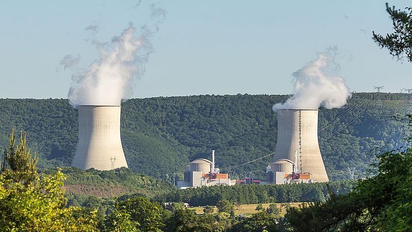 Blick auf das Kernkraftwerk Chooz in Frankreich, mit zwei rauchenden Wasserdampfschloten