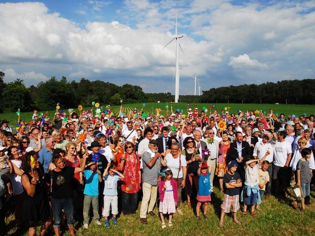 Menschengruppe vor einem Windrad in der Bretagne/Frankreich