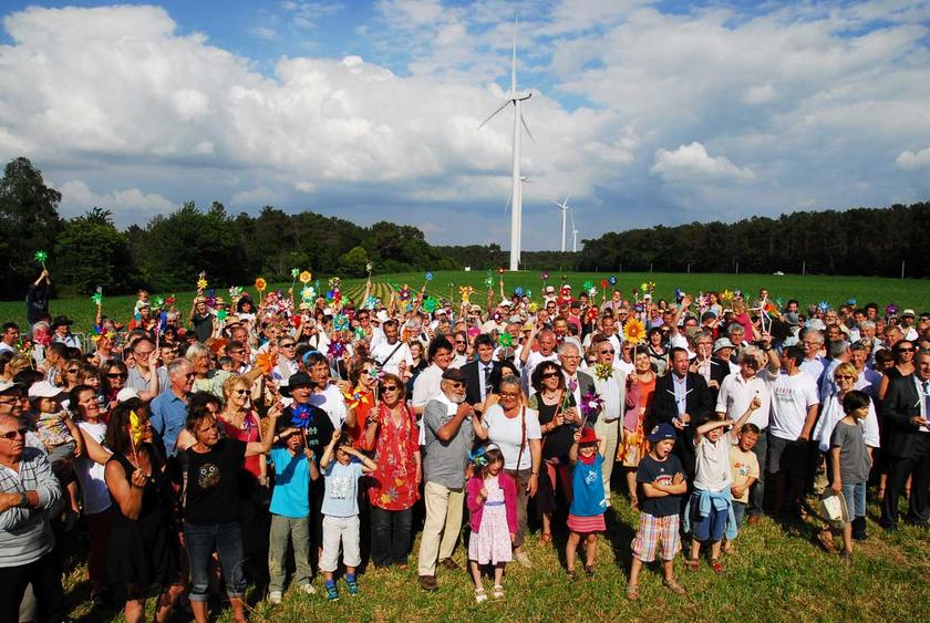 Menschengruppe vor einem Windrad in der Bretagne/Frankreich