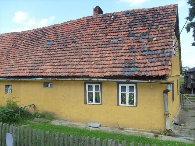 Ein niedriges altes gelbes Gebäude mit roten Dachziegeln 