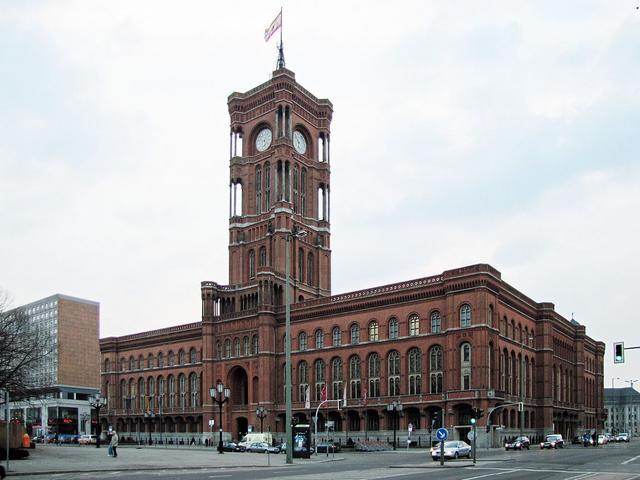 ein langgezogenes rotes Gebäude mit Turm und Uhr