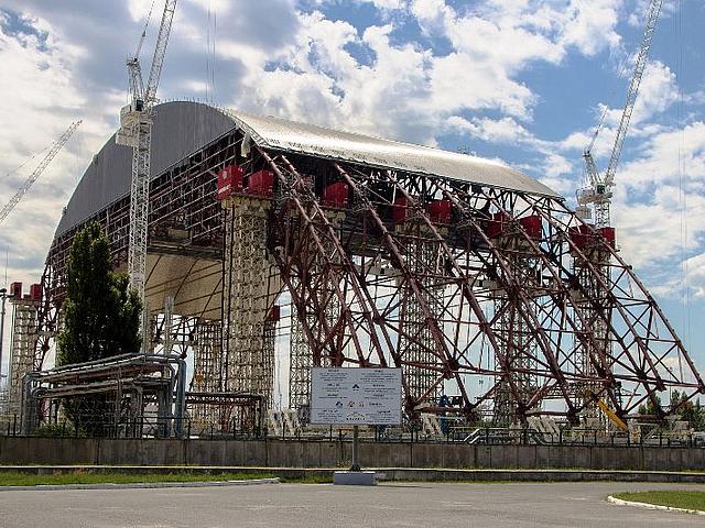 Nur 100 Meter neben dem Beton-Sarkophag, der über dem zerstörten Atomreaktor in Tschernobyl errichtet wurde, ist nun eine Freiland-Solaranlage installiert worden. Weitere sollen folgen. Der Plan gefällt allerdings nicht jedem.  (Foto: <a href="https://commons.wikimedia.org/wiki/File%3ATschernobyl_2013_2.jpg" target="_blank"> Arne Müseler / www.arne-mueseler.de </a>, <a href=" https://creativecommons.org/licenses/by-sa/3.0/de/deed.en " target="_blank"> CC BY-SA 3.0 </a>)