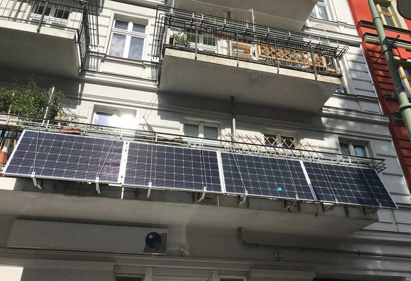 Vier Solarmodule an einer Balkonbrüstung