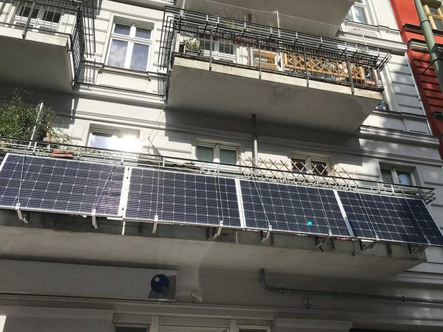 Vier Solarmodule an einer Balkonbrüstung