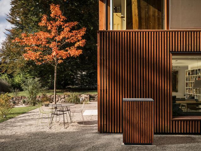 Einfamilienhaus mit Holzfassade, Außen-Wärmepumpe in gleicher Optik