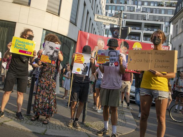 Fünf Demonstranten halten Schilder gegen die FDP hoch