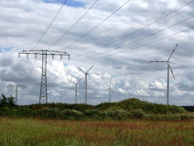 Windenergieanlagen und Stromnetz in grüner Landschaft