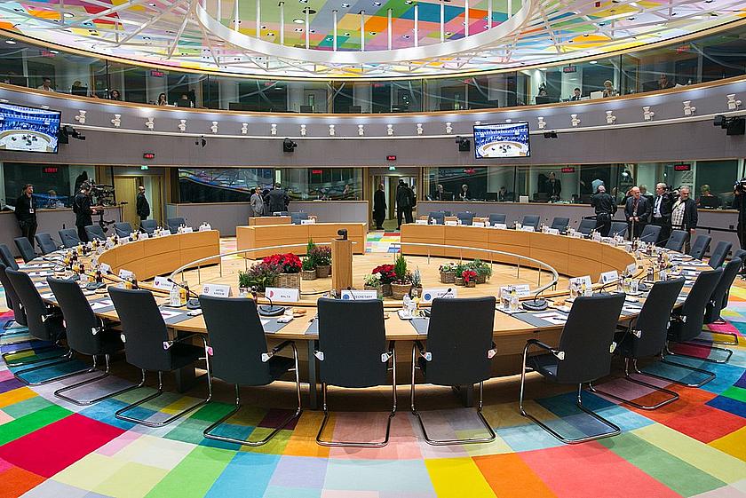 Blick in den Tagungsort des Rates der Europäischen Union, mit Stühlen an einer runden Tischfront