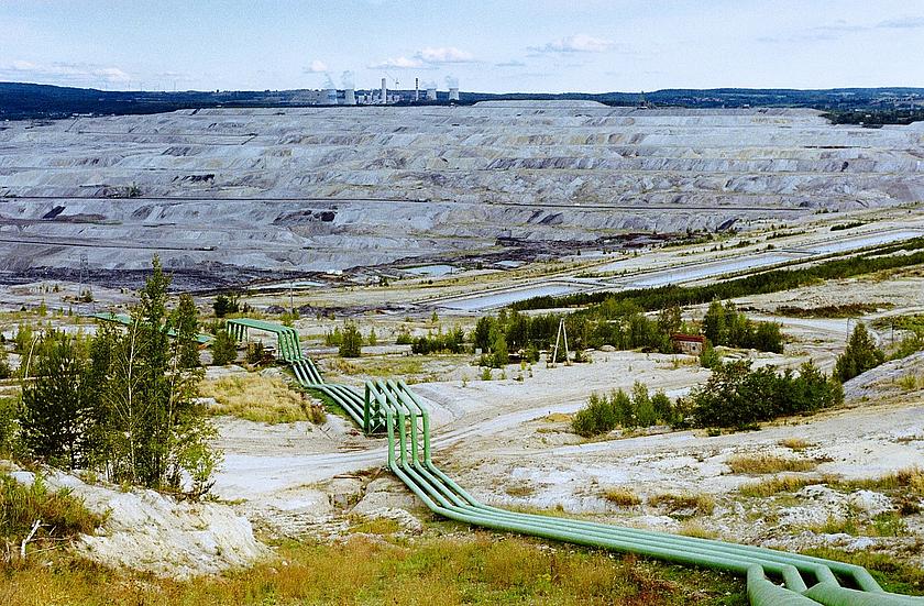 Der Tagebau Turów erstreckt sich einschließlich der Abraum- und Aschenhalde über eine Fläche von rund 50 km². Im Hintergrund ist das dazugehörige Kohlekraftwerk zu sehen.