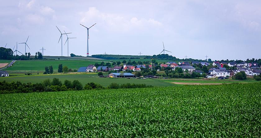 Dorf mit Windrädern im Hintergrund