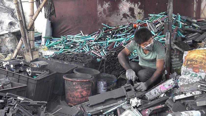 Dieser Arbeiter in der chinesischen Provinz Guangdong zerlegt auf dem sogenannten Friedhof des Elektronikschrotts in der Stadt Guyiu Tonerkartuschen in ihre Einzelteile (Foto: <a href="https://flic.kr/p/f7kAGD" target="_blank">baselactionnetwork/flickr.co