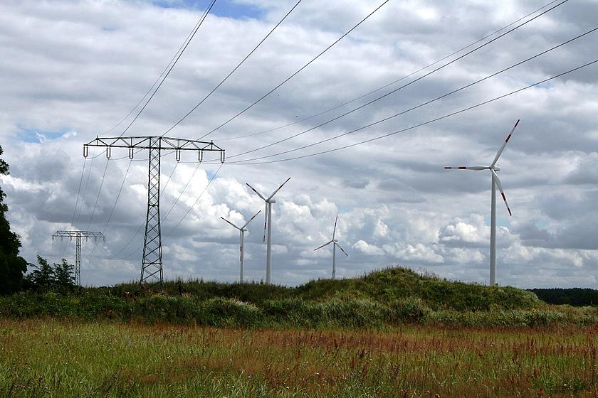 Stromnetze und Windkraftanlagen in grüner Landschaft