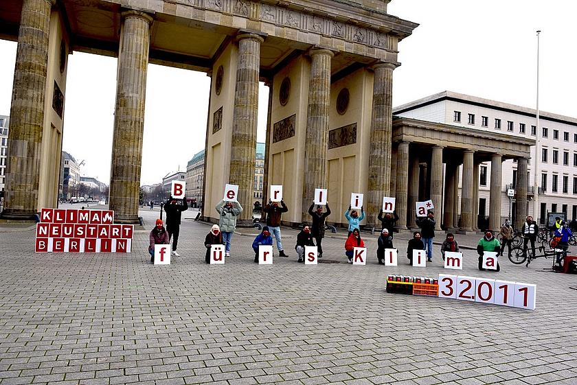 Klimaaktivisten am Brandenburger Tor zeigen Buchstaben in die Höhe, die zusammen den Satz ergeben: "Berlina* fürs Klima