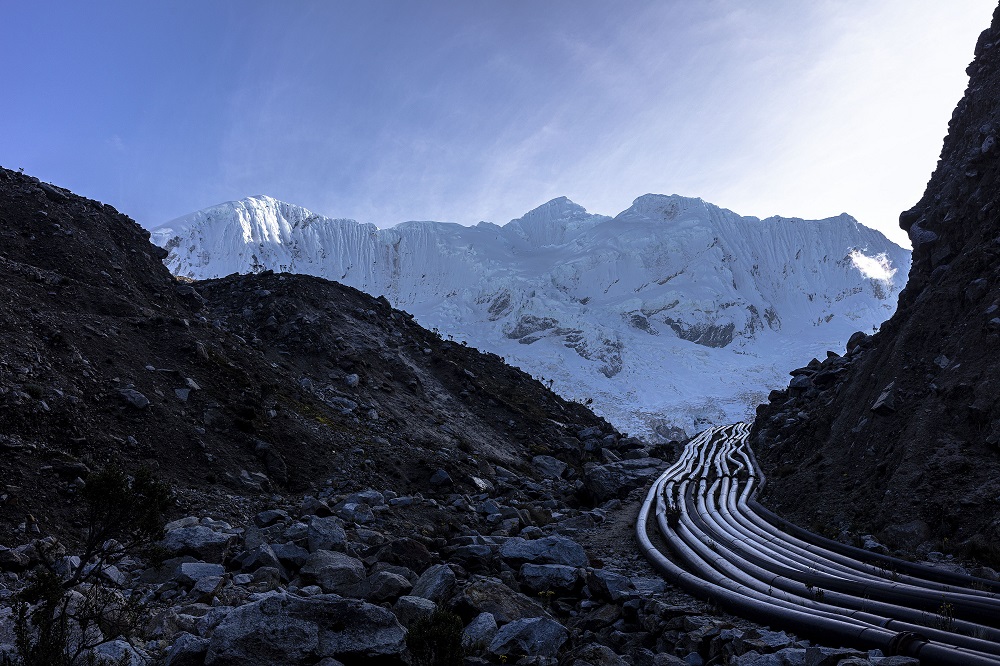 Mehrere Rohrleitungen vor einem Gletscher in den Bergen