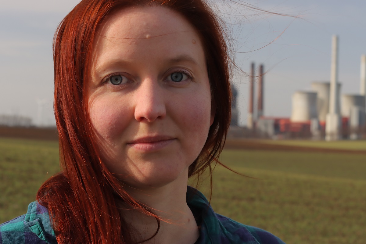 Profilbild von Kathrin Henneberger mit einem Kohlekraftwerk im Hintergrund