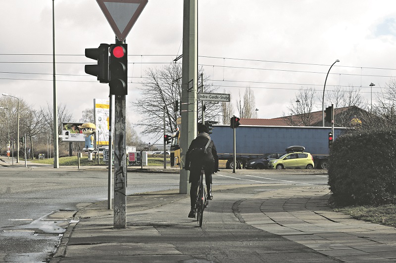 Eine Frau fahrt auf einem Fahrrad regelgerecht an einer roten Ampel vorbei