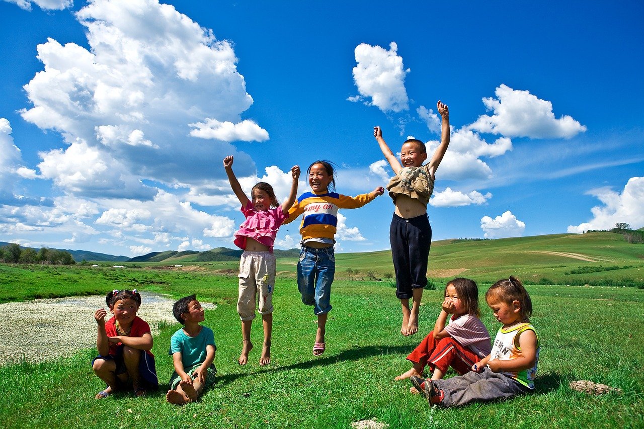 Kinder auf einer Wiese in der Mongolei